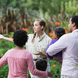 Travel guide showing tourists around in an outdoor space